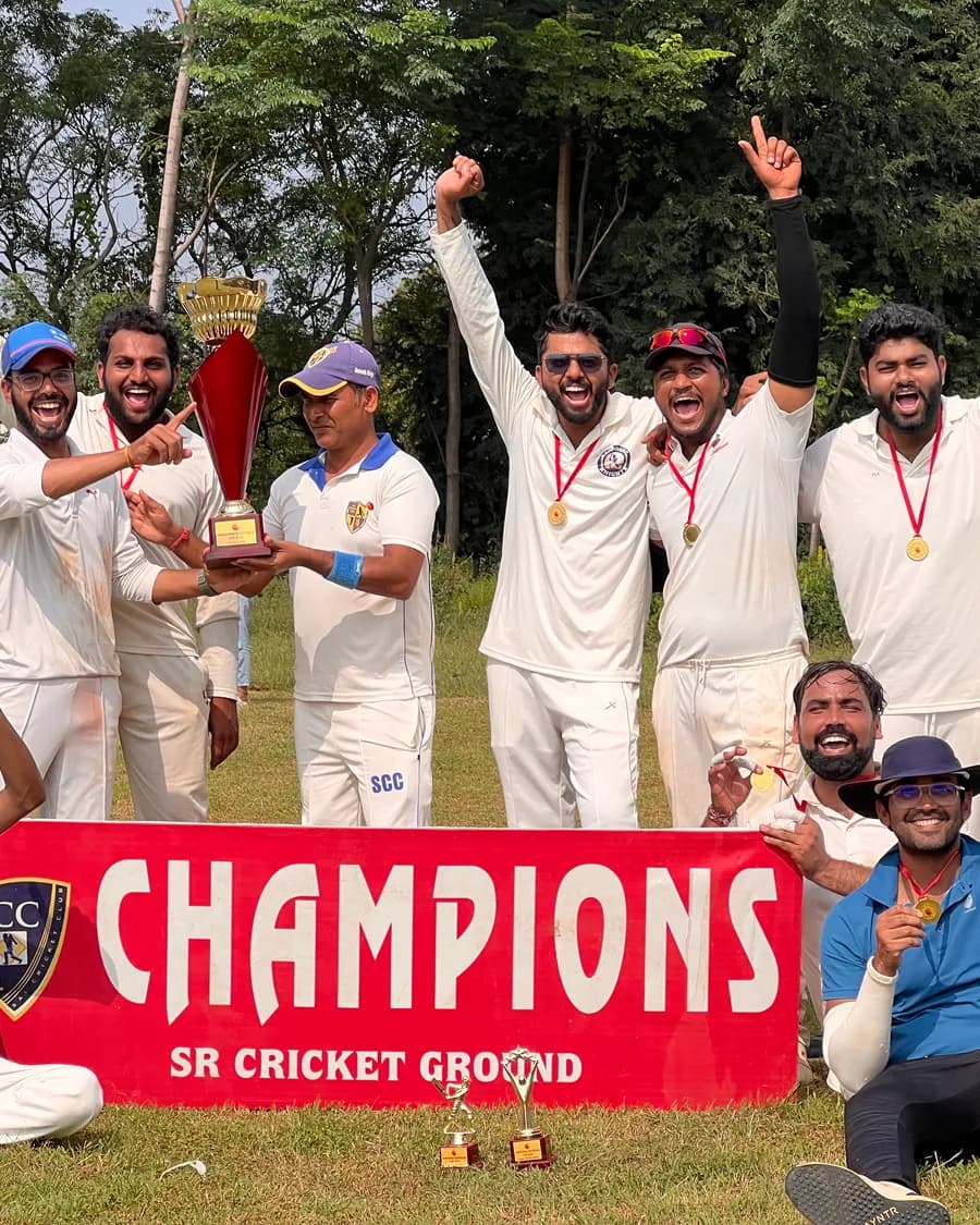 Sandeep's cricket team celebrating with a trophy behind a champions banner